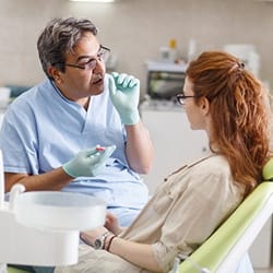 Dentist talking to female patient in dental chair