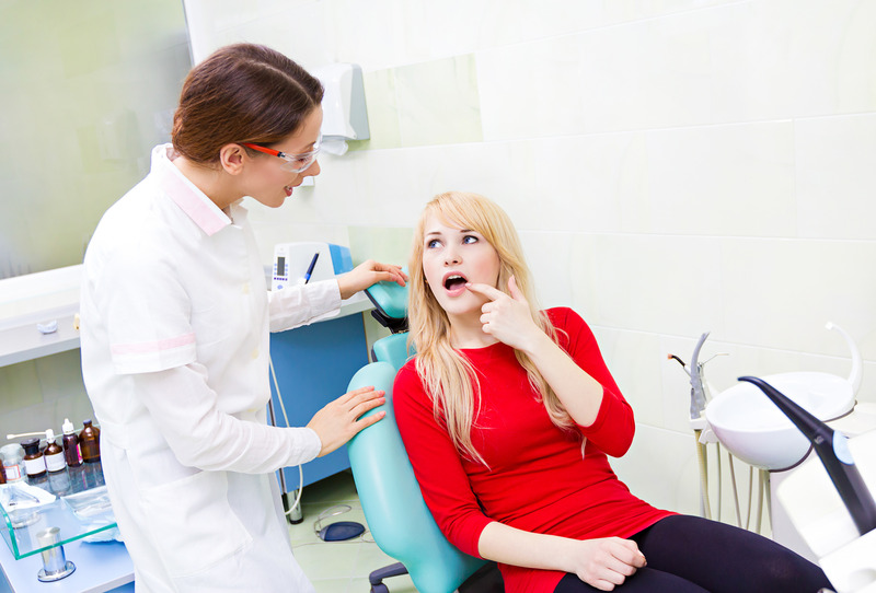 Patient looking at dentist in pain due to dry socket