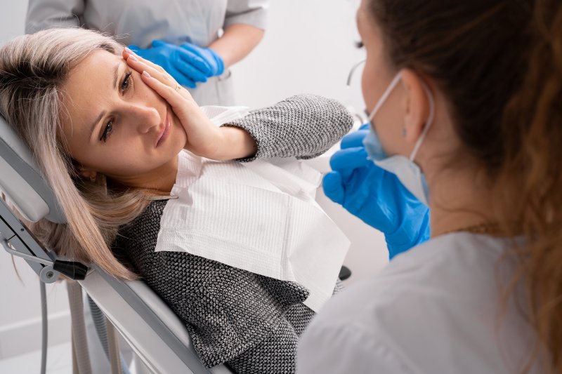 Lady has oral pain in dentist's chair